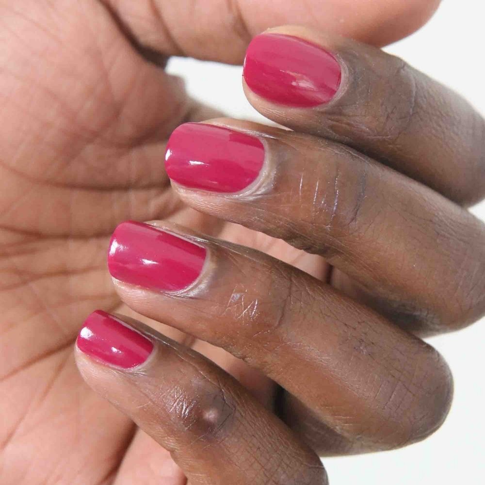 Hand mit lackierten Nägeln. Nägel mit pinkfarbenem Nagellack lackiert. Nahaufnahme der Hand.