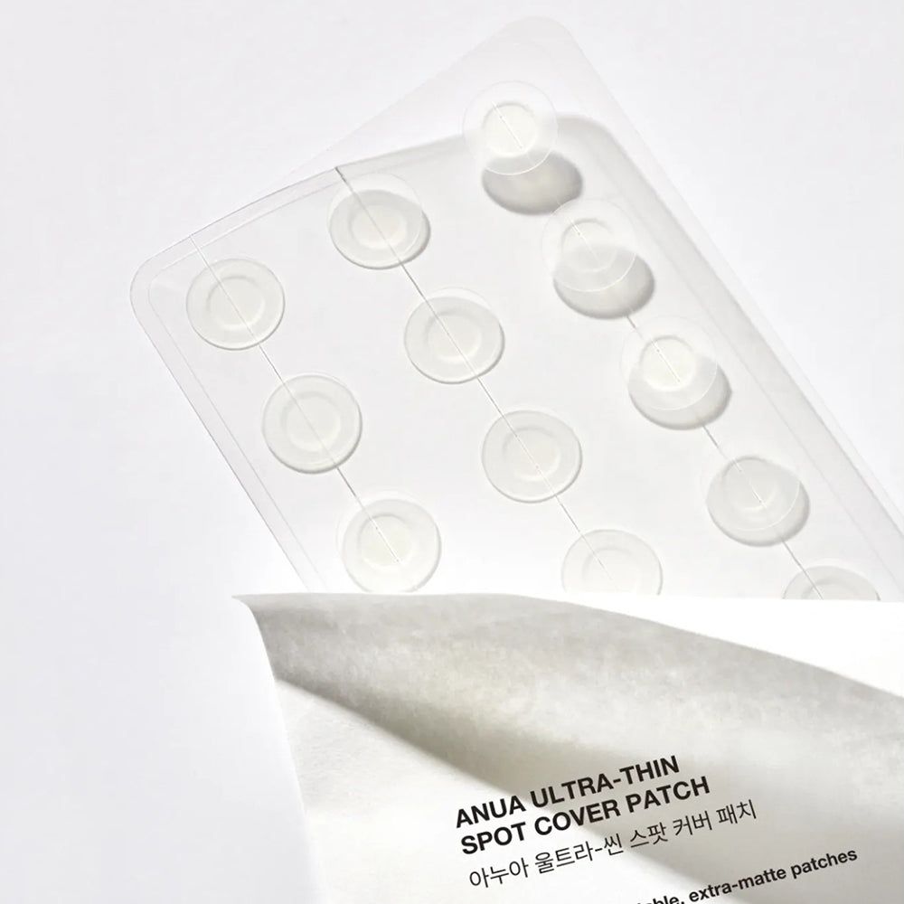 Transparente Kunststoffverpackung mit runden Pflastern. Darunter ein Blatt mit Produkttext. Anua Ultra-Thin Spot Cover Patch.