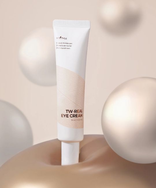 Weiße Tube mit Aufschrift TW REAL EYE CREAM. Beige Musterung. Produktname und Marke deutlich sichtbar, vor Hintergrund.
