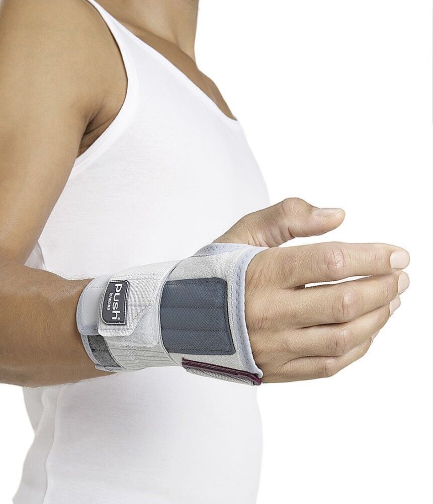 Person trägt Handgelenkbandage. Weiß-grau, mit Klettverschluss. Marke Push med sichtbar.
