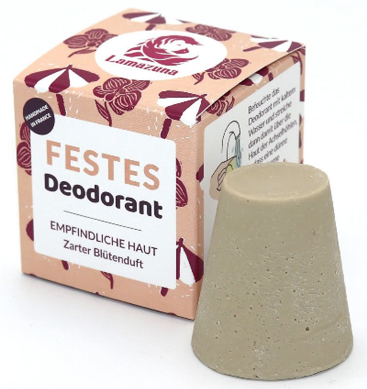 Beige Deodorant-Stift neben Verpackung. Verpackung mit Logo und Text: FESTES Deodorant, EMPFINDLICHE HAUT, Zarter Blütenduft. "Handmade in France".