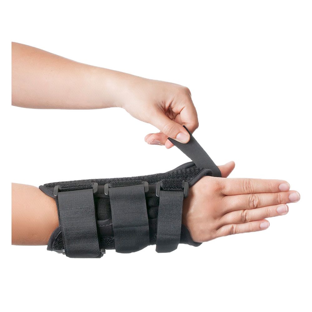 Handgelenkorthese mit Daumenfixierung. Hand öffnet Klettverschluss. Schwarzes Material.