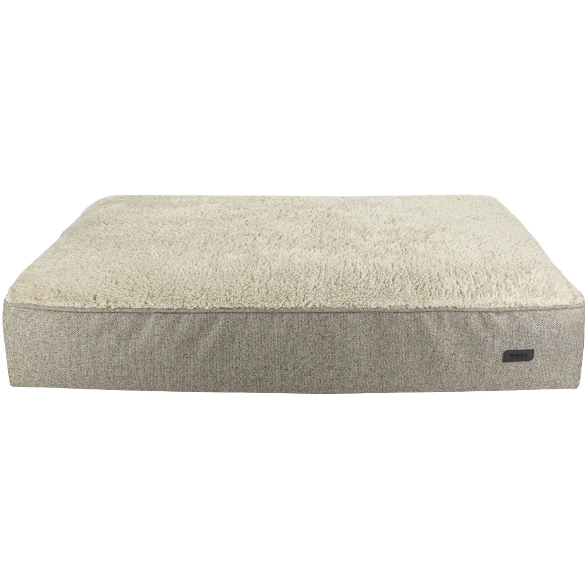 Beige Hundebett mit flauschiger Oberfläche und grauem Rand. Rechteckige Form, flach. Kleines Label an der Seite.