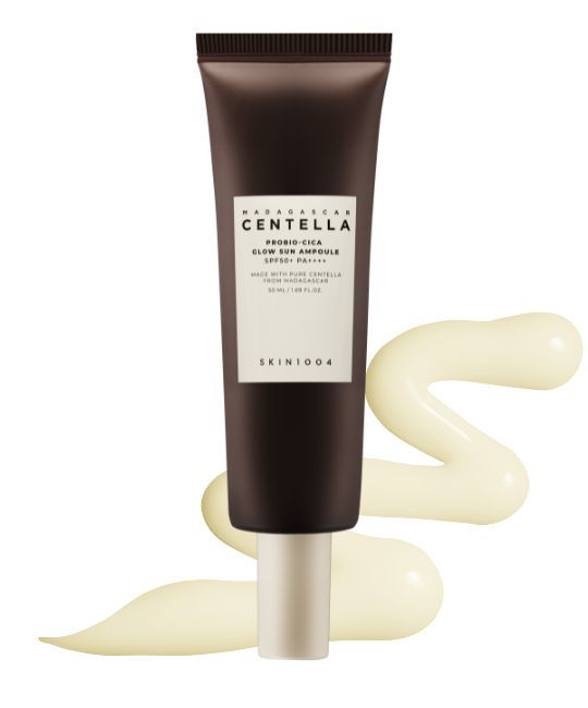 Braune Tube mit weißem Etikett. Text: MADAGASCAR CENTELLA, PROBIO-CICA GLOW SUN AMPULLE SPF50+ PA++++. Gelbe Produktspur.
