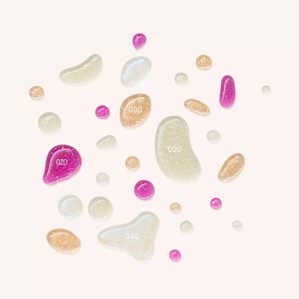 Verschiedene Tropfen Nagellack. Einige Tropfen sind mit Glitzer versehen. Verschiedene Farben und Formen.