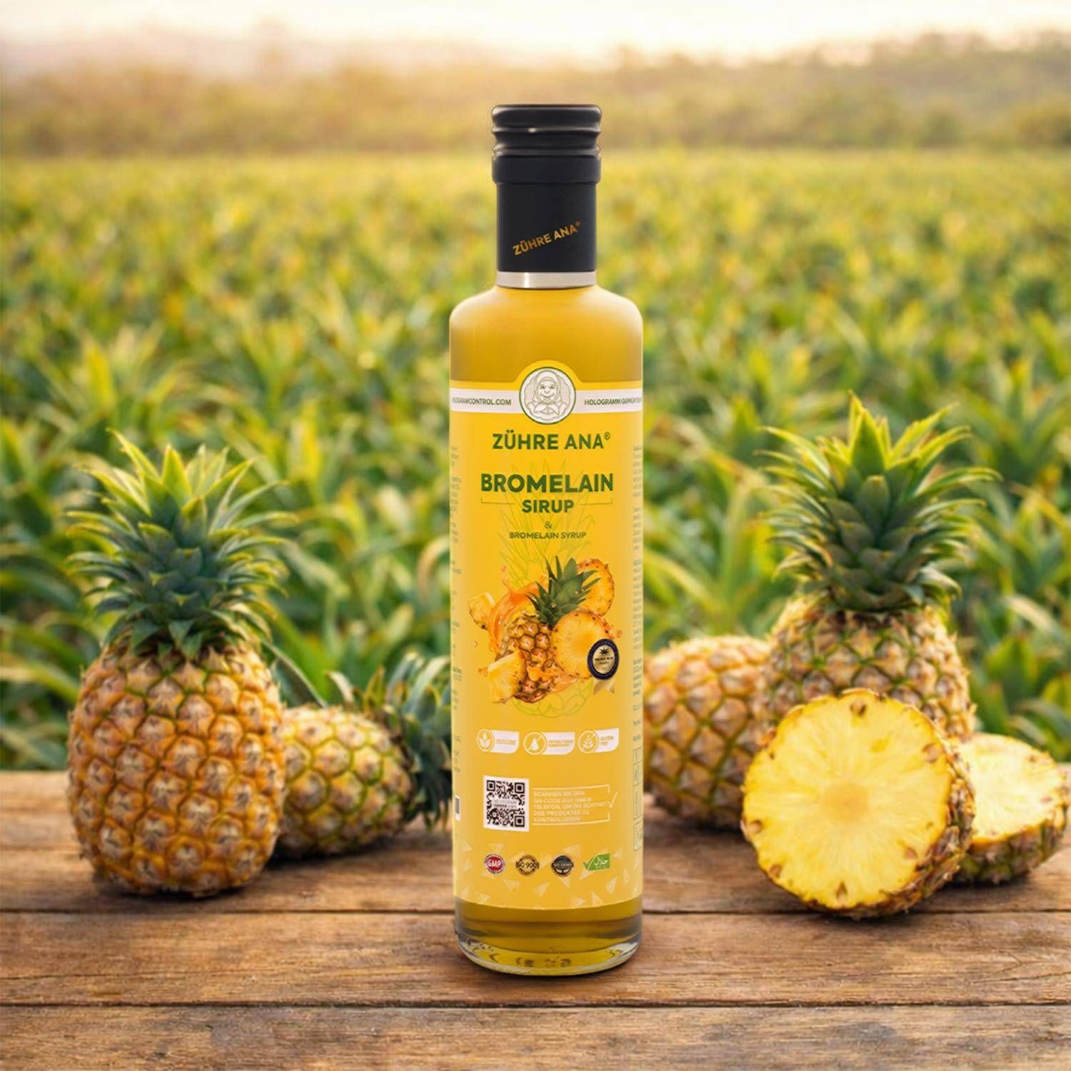 Flasche Zühre Ana Bromelain Sirup auf Holztisch mit Ananas im Hintergrund.