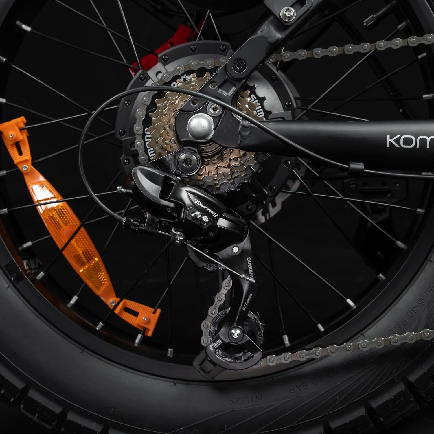 Hinterrad mit Gangschaltung und orangefarbenem Reflektor. Schwarze Komponenten.