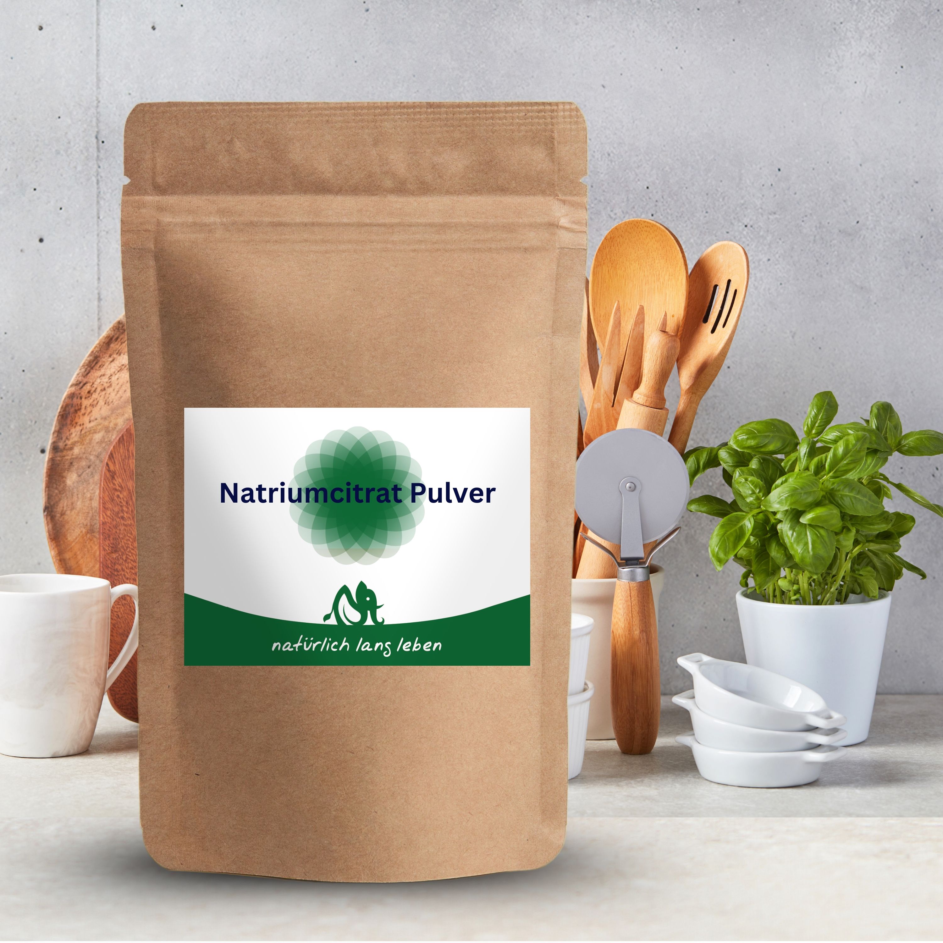 Braune Pulverpackung mit Etikett. Aufschrift: Natriumcitrat Pulver. Logo: grünes Blattmuster und Schriftzug. Küche im Hintergrund.
