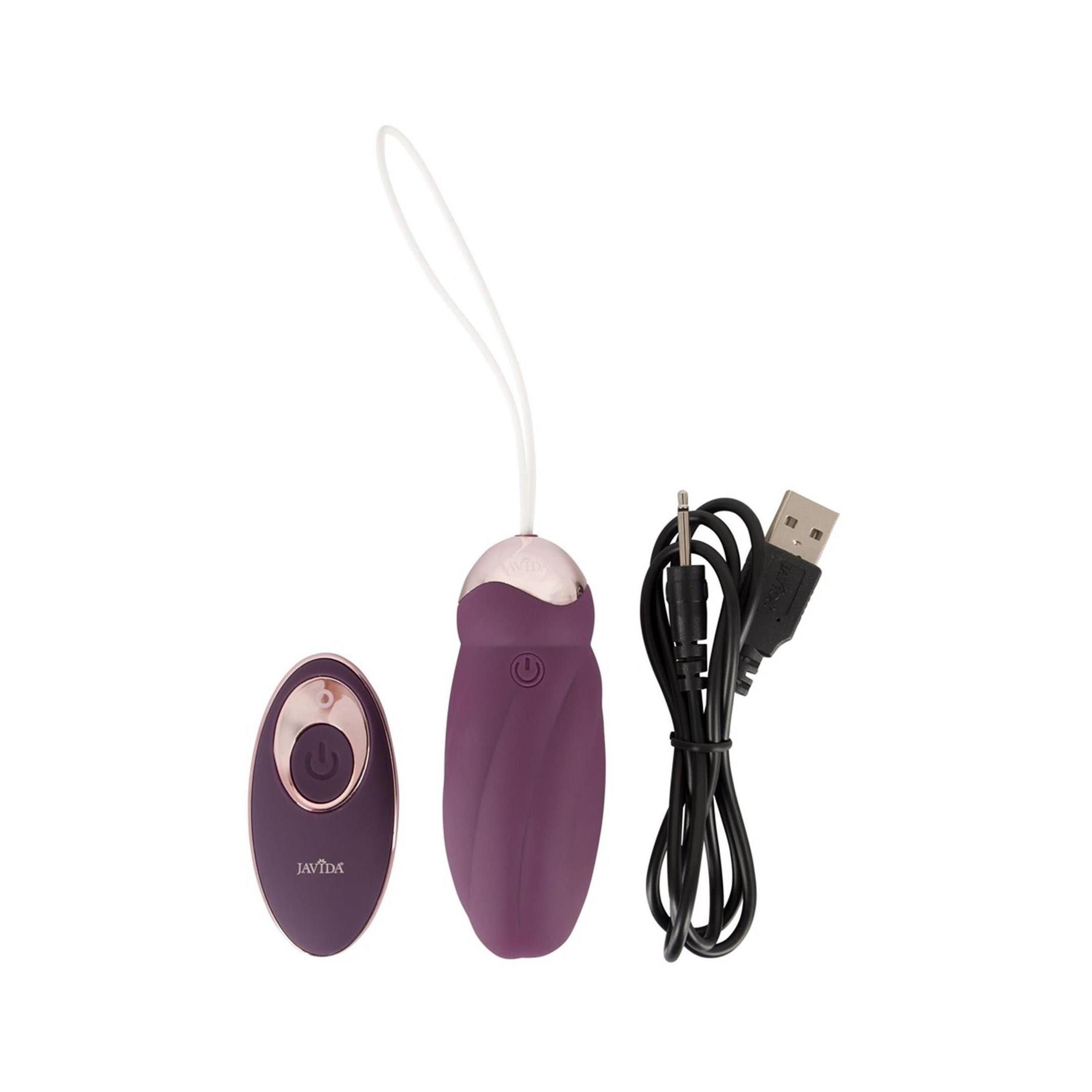 Lila Vibrator, Fernbedienung und USB-Kabel. Goldfarbene Akzente. Auf der Fernbedienung ist ein Knopf.