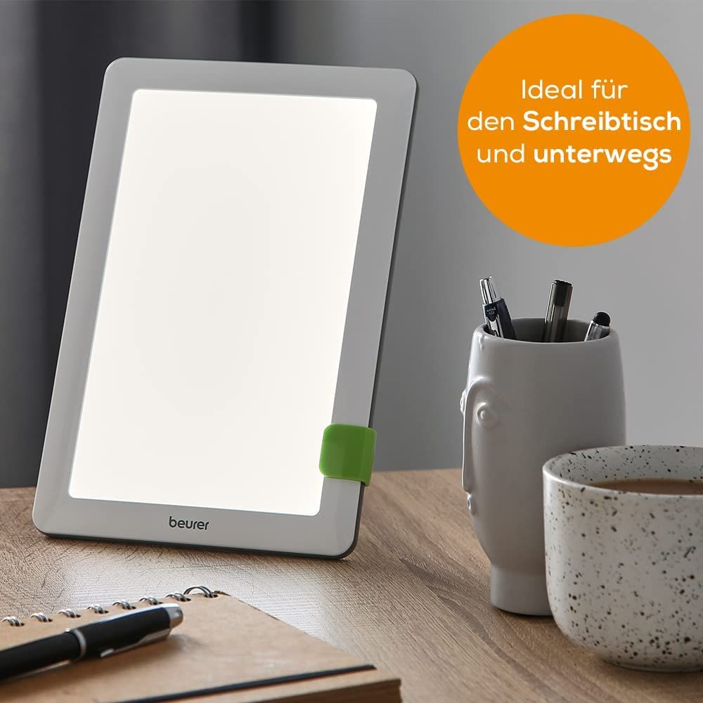Tageslichtlampe auf Tisch. Text: Ideal für den Schreibtisch und unterwegs. Marke: beurer.