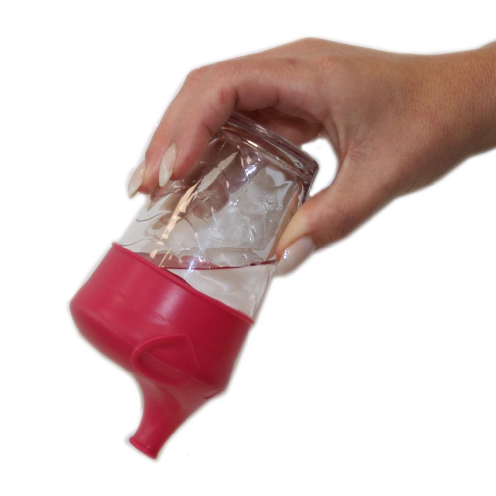 Roter Silikon-Deckel mit Schnabelaufsatz an Glas. Glas mit Wasser wird geneigt. Weißer Hintergrund.