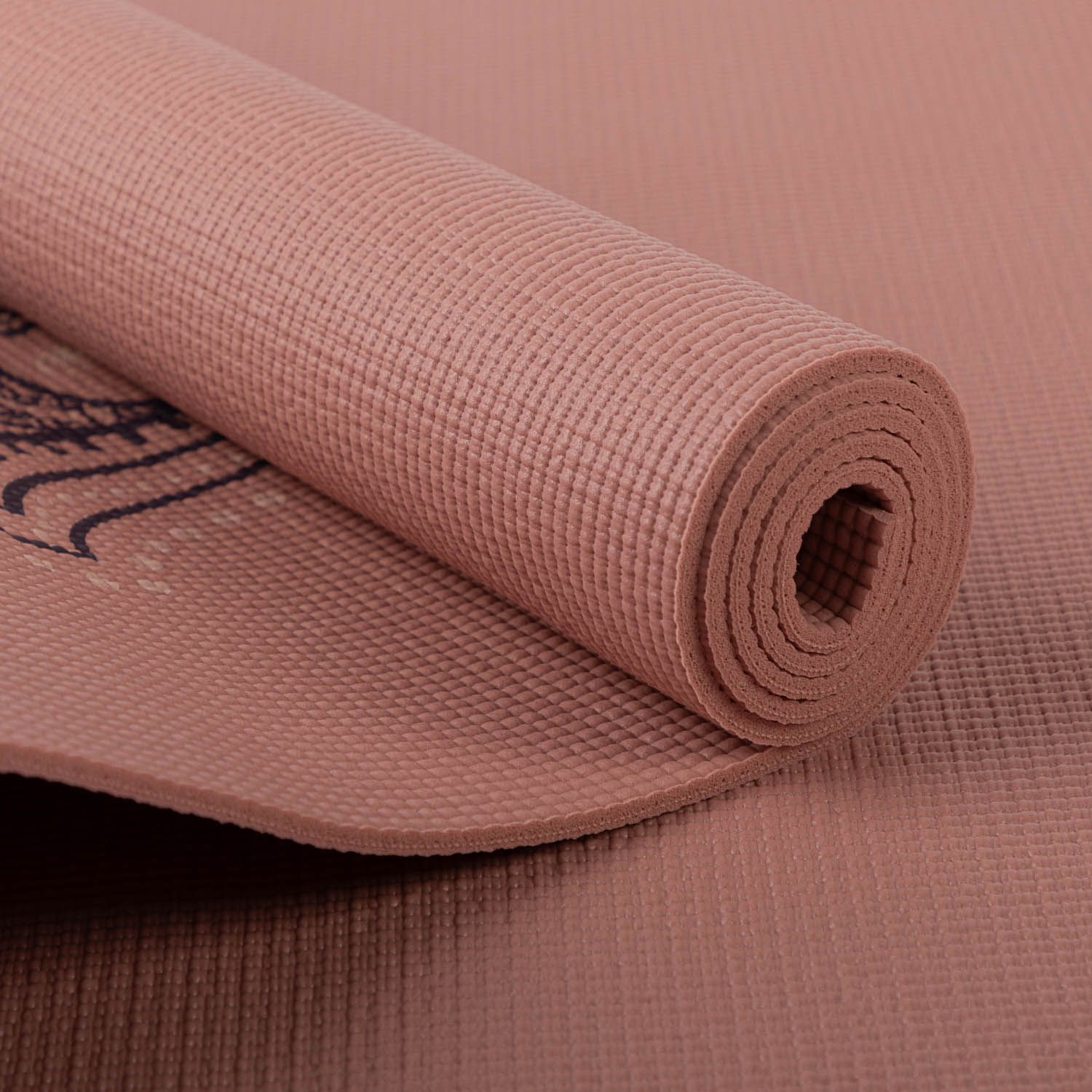 Gerollte Yogamatte, rosa. Hamsa-Hand-Design teilweise sichtbar. Strukturierte Oberfläche.