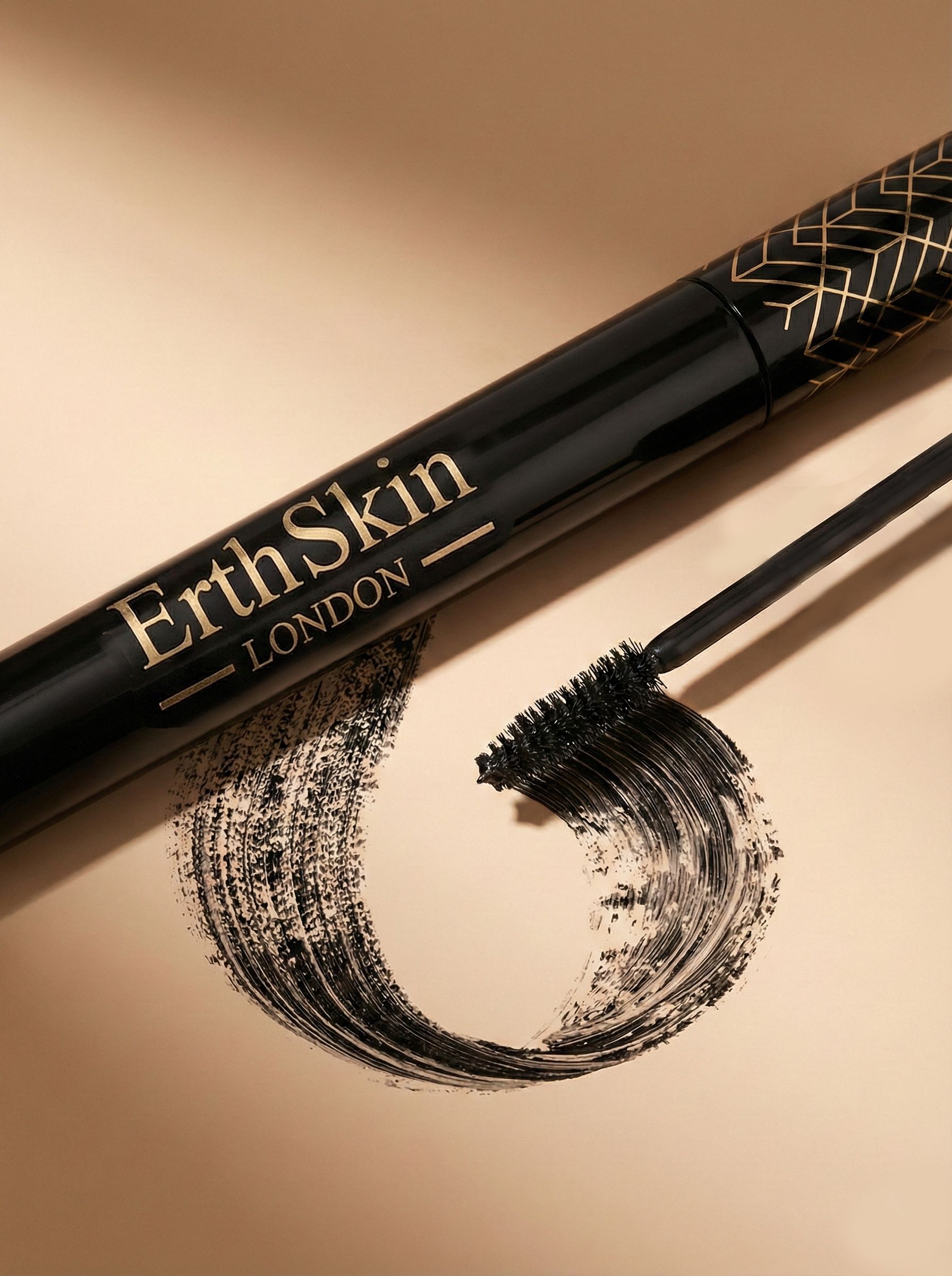 Schwarze Mascara mit goldener Schrift 'ErthSkin LONDON' und aufgetragener Bürste.
