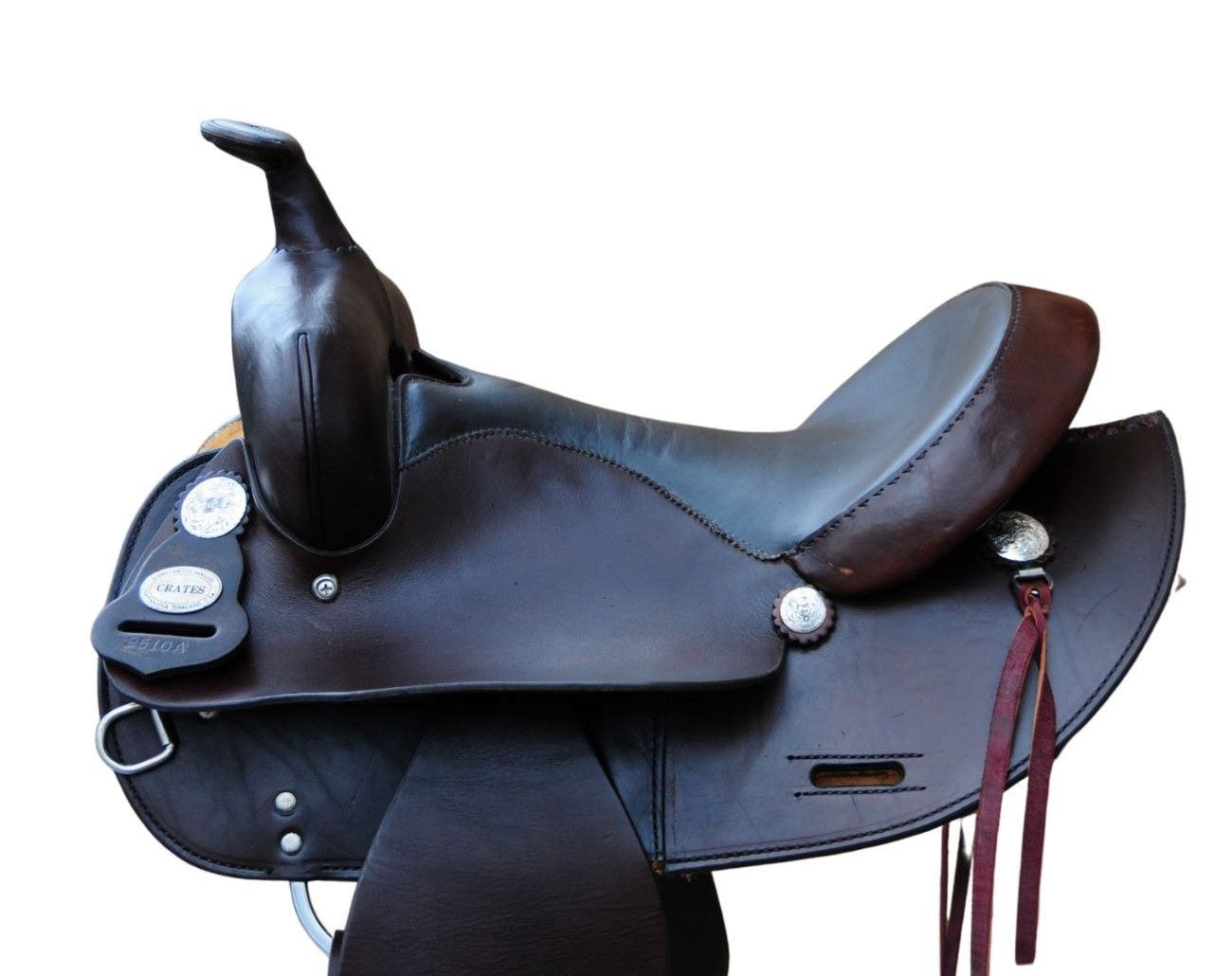 Brauner Westernsattel. Leder, Steigbügel, Ziernähte. Silberfarbene Verzierungen. Riemen mit Quasten.