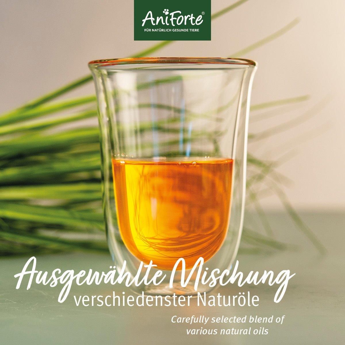 Doppelwandiges Glas mit goldgelber Flüssigkeit. Text: Ausgewählte Mischung verschiedenster Naturöle. Grüne Halme im Hintergrund.