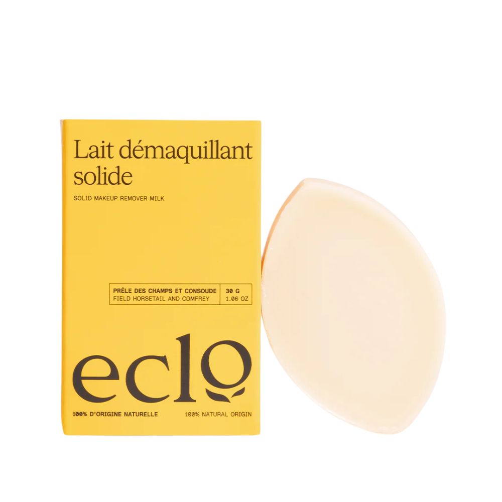Gelbe Verpackung mit Produktnamen und Logo. Daneben ein ovales, cremefarbenes Produkt. Text: Lait démaquillant solide, eclo.