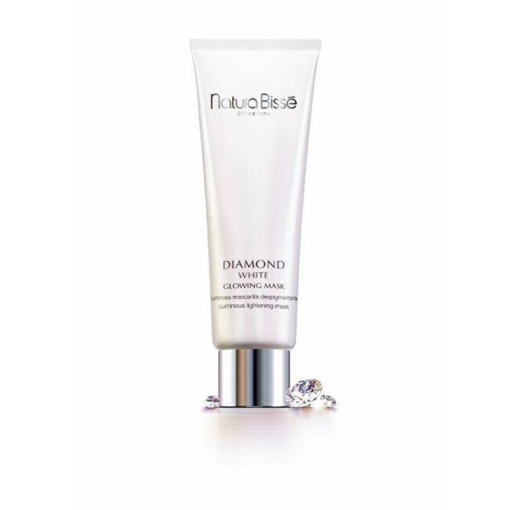 Weiße Tube mit Produkttext. Aufschrift: Natura Bissé, Diamond White Glowing Mask. Zwei Diamanten liegen daneben.