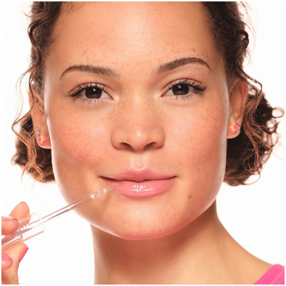 Nahaufnahme eines Gesichts. Eine Person trägt Lipgloss auf. Der Applikator berührt die Lippen. Rosa Lippen.