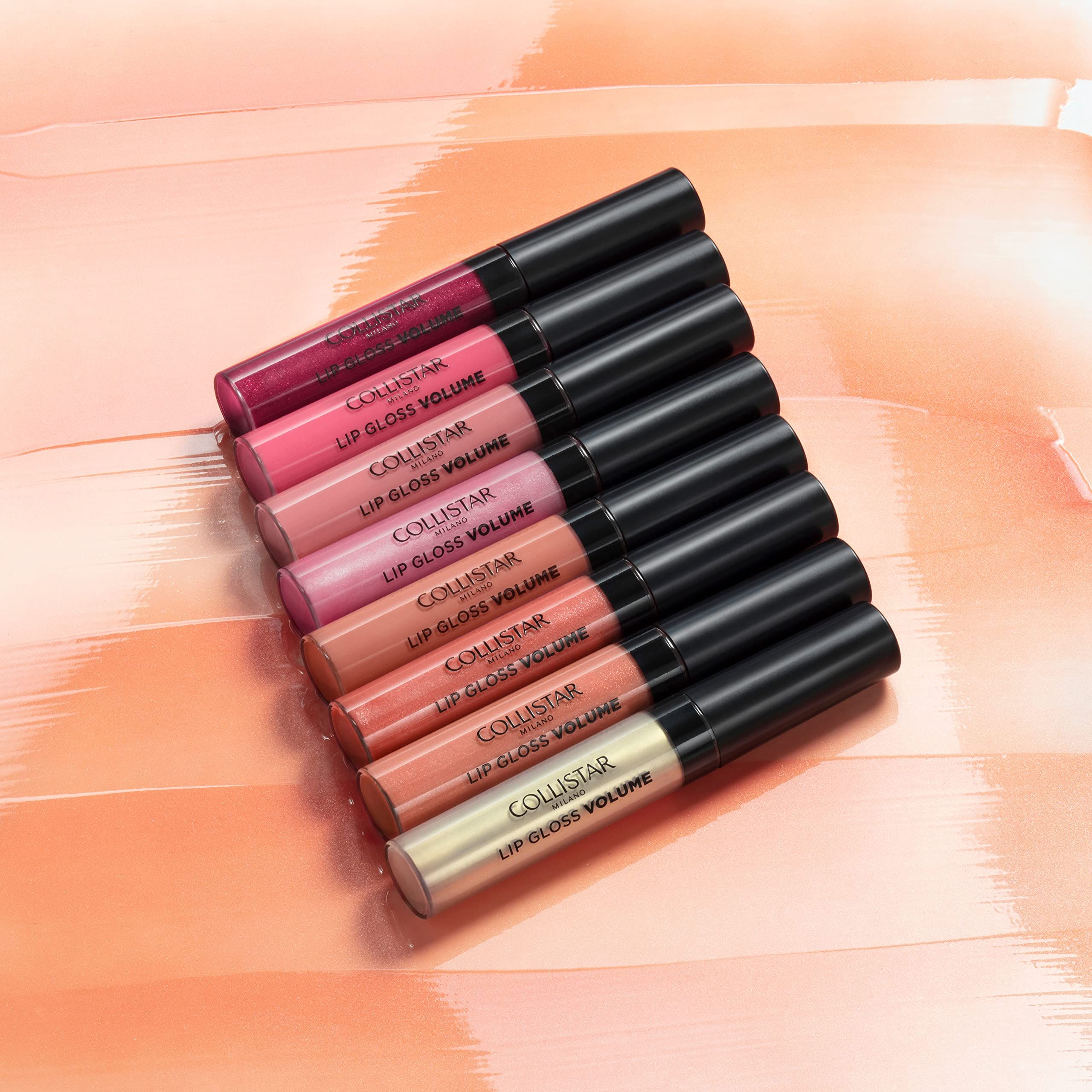Sieben Lipglosse in verschiedenen Farben. Schwarze Deckel. Aufschrift: COLLISTAR LIP GLOSS VOLUME.