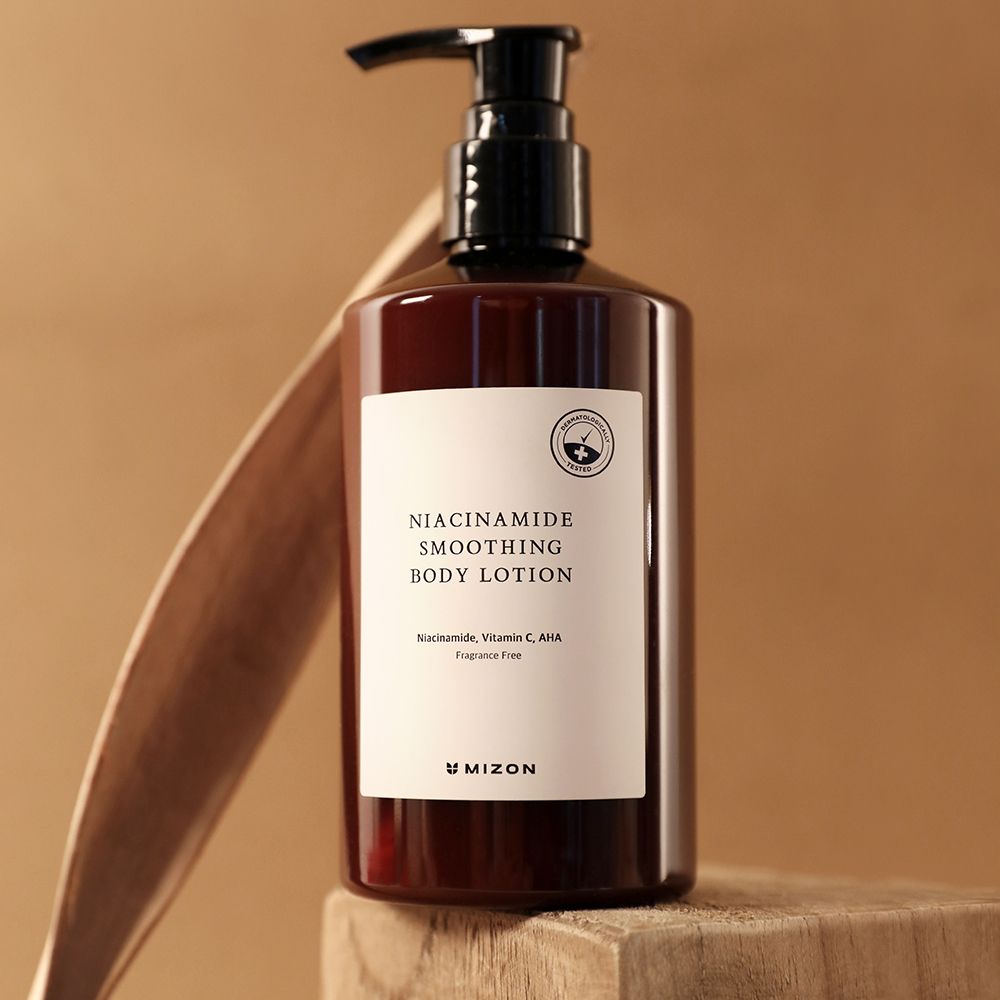 Braune Flasche mit schwarzem Pumpverschluss. Weißes Etikett mit Text: Niacinamide Smoothing Body Lotion. Marke MIZON.