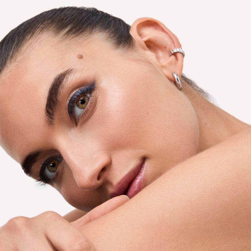 Nahaufnahme eines Gesichts. Das Model trägt blauen Eyeliner. Hautton hell.