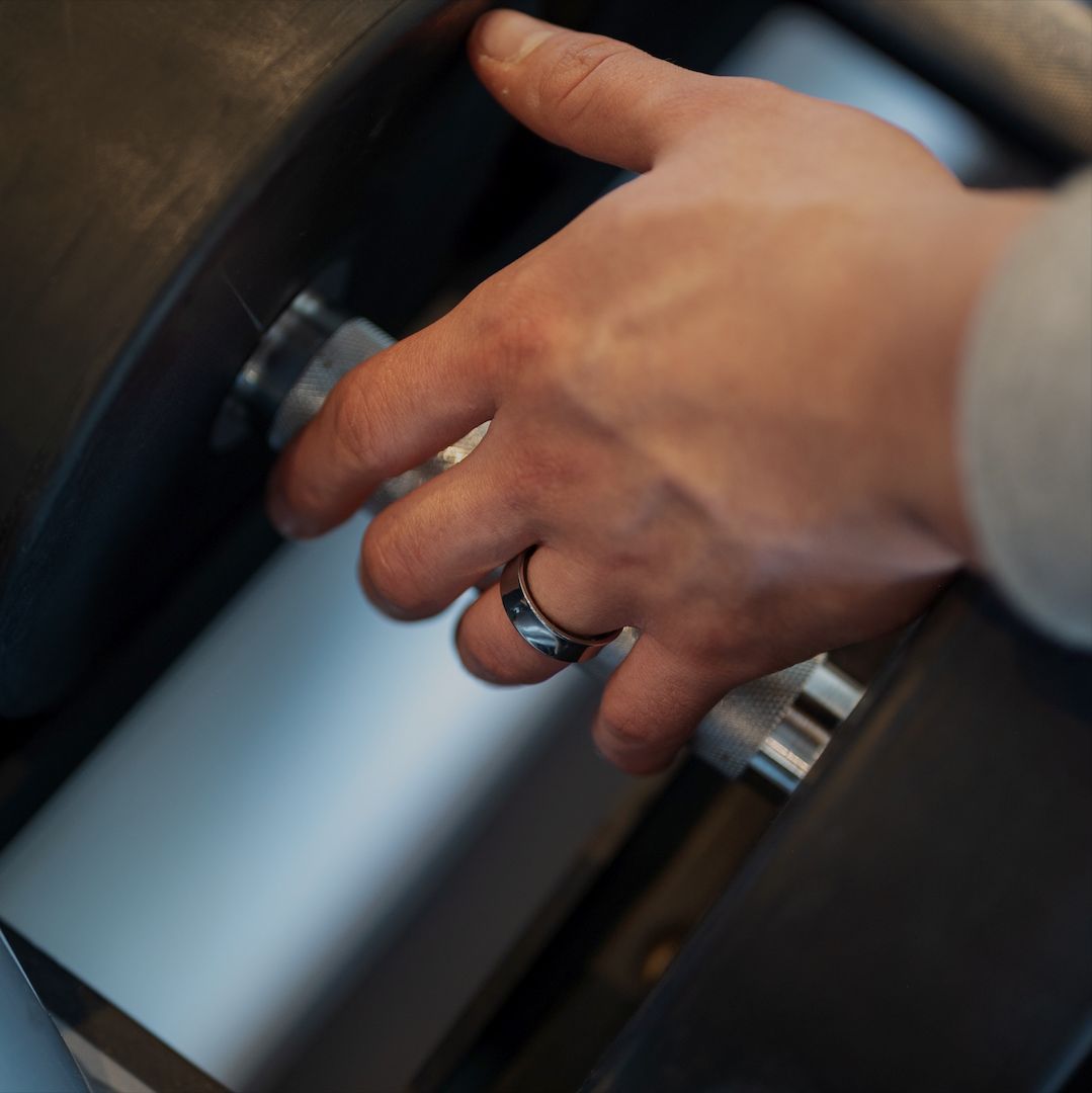 Hand mit Ring am Finger. Ring ist schwarz und silberfarben. Der Ring ist am Finger.