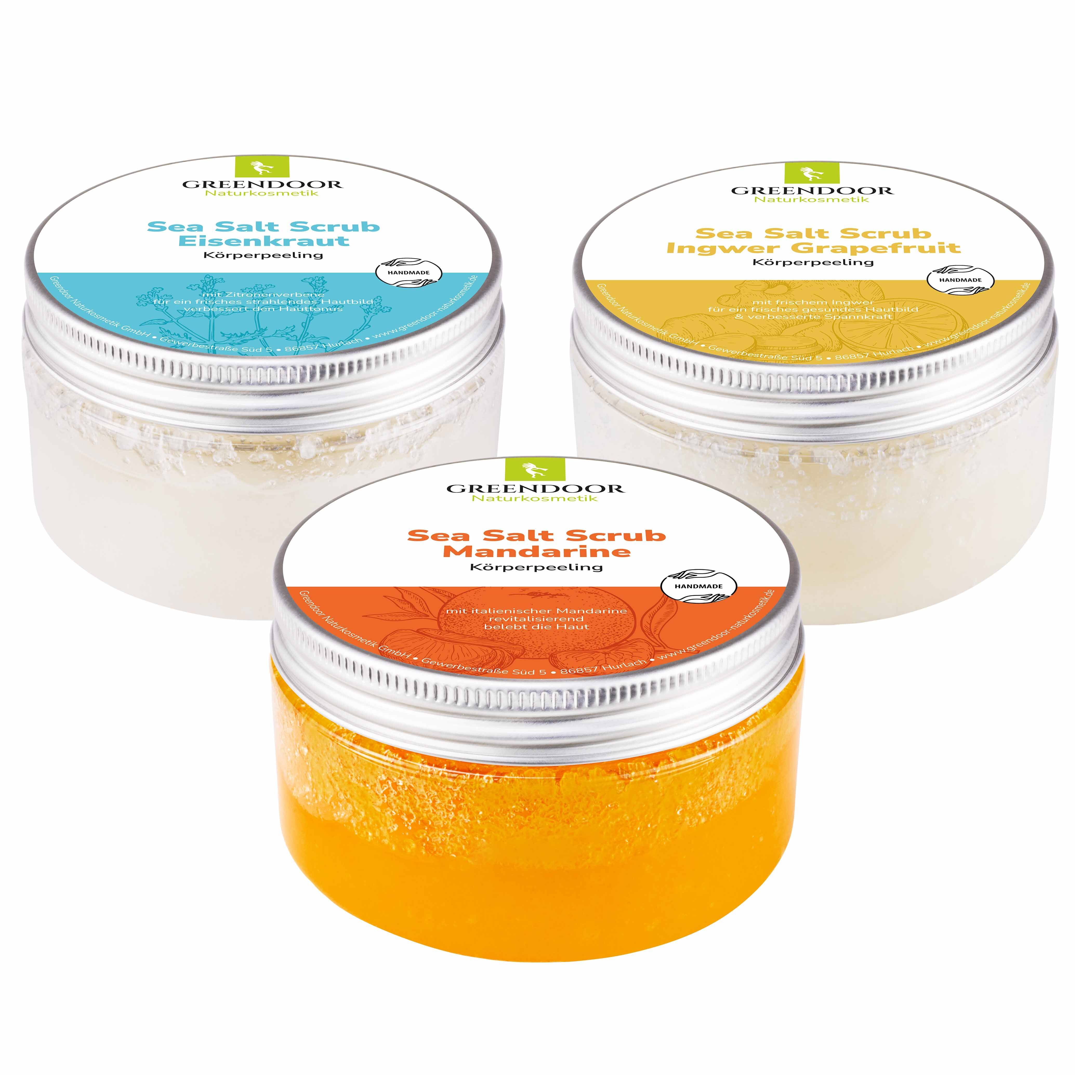 Drei GREENDOOR Sea Salt Scrubs in Gläsern: Eisenkraut, Ingwer Grapefruit, Mandarine.