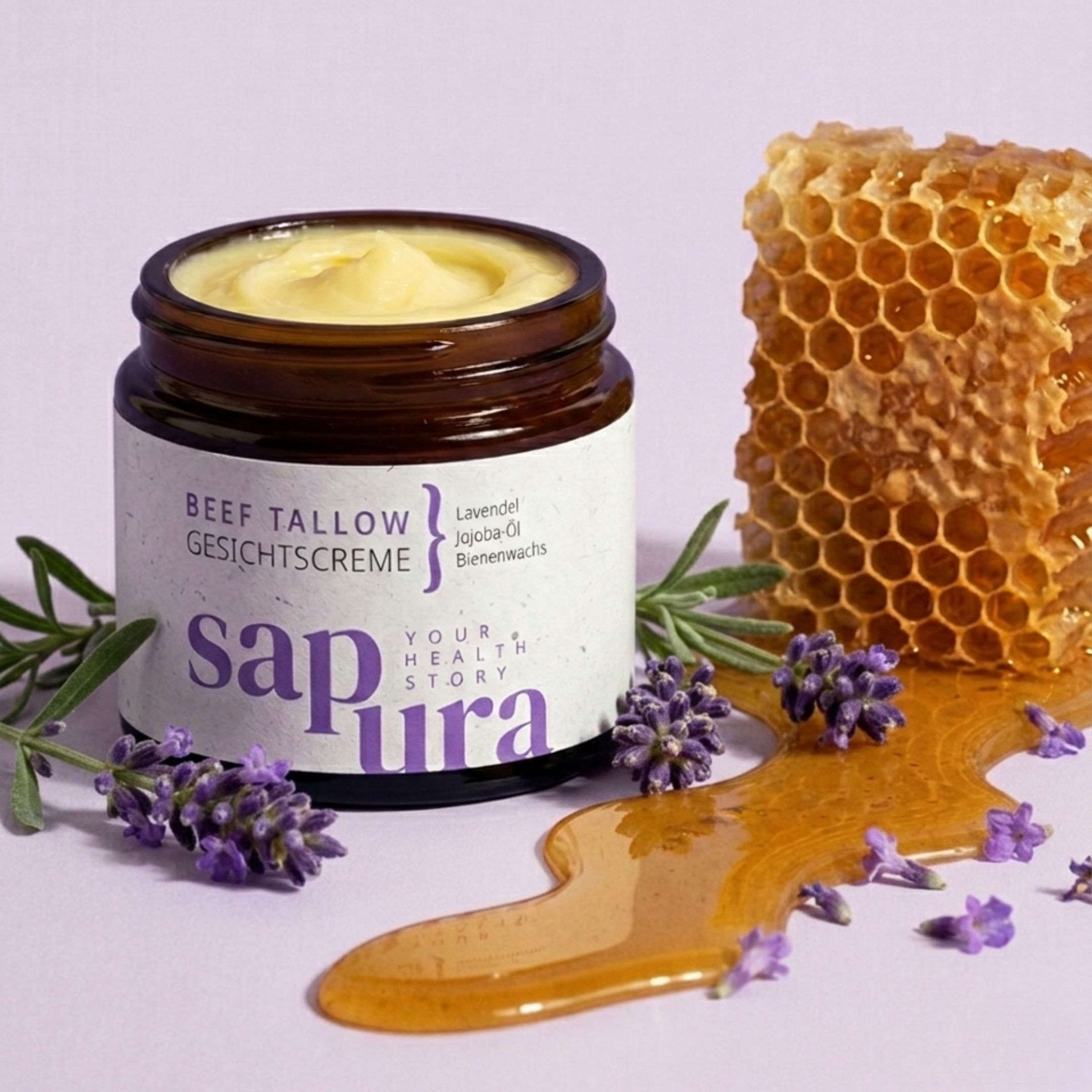 Creme-Glas, Honig, Honigwabe, Lavendelzweige. Aufschrift: BEEF TALLOW GESICHTSCREME, Lavendel, Jojoba-Öl, Bienenwachs. Marke: sapura.