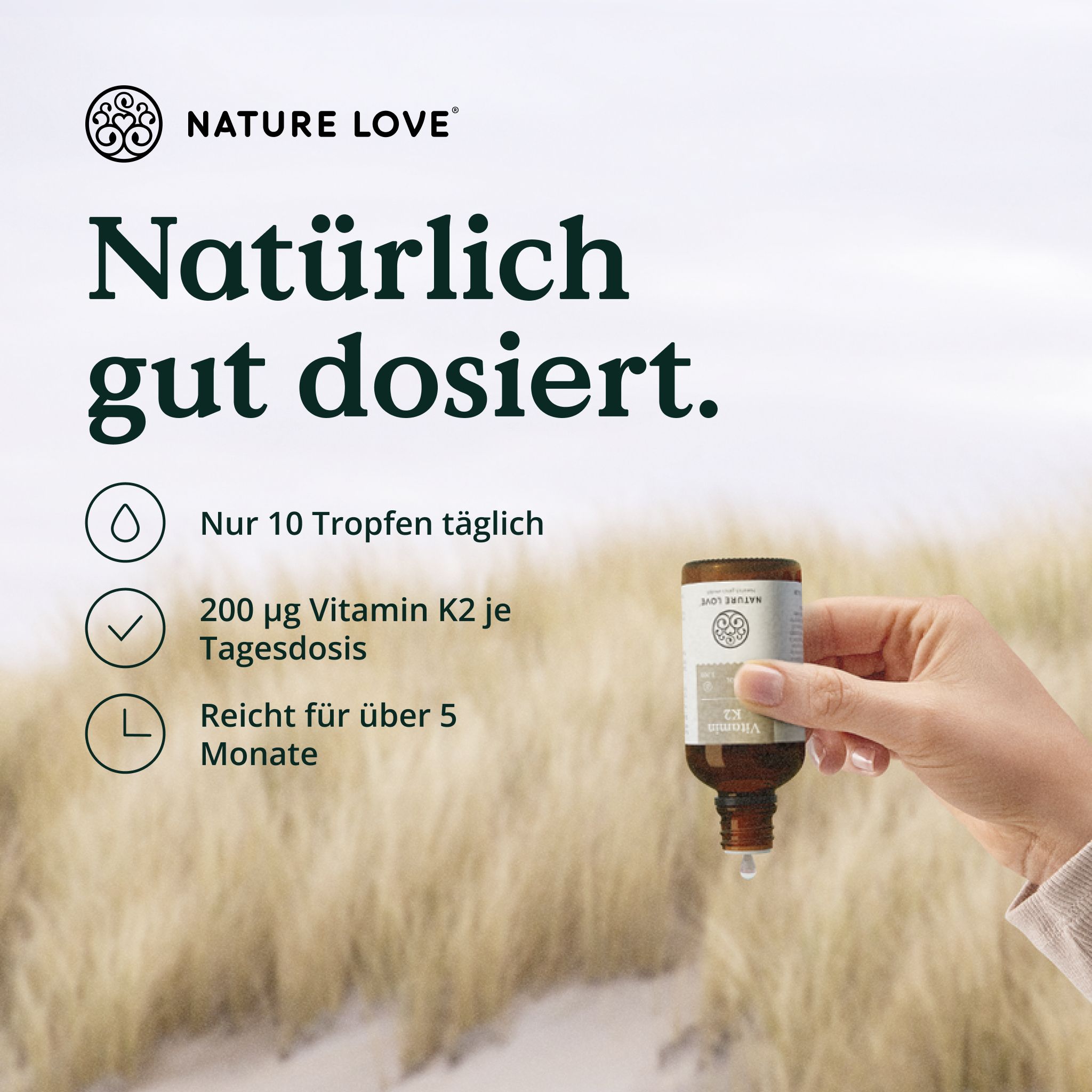 Hand hält Flasche Vitamin K2 von Nature Love, ein Tropfen fällt heraus.