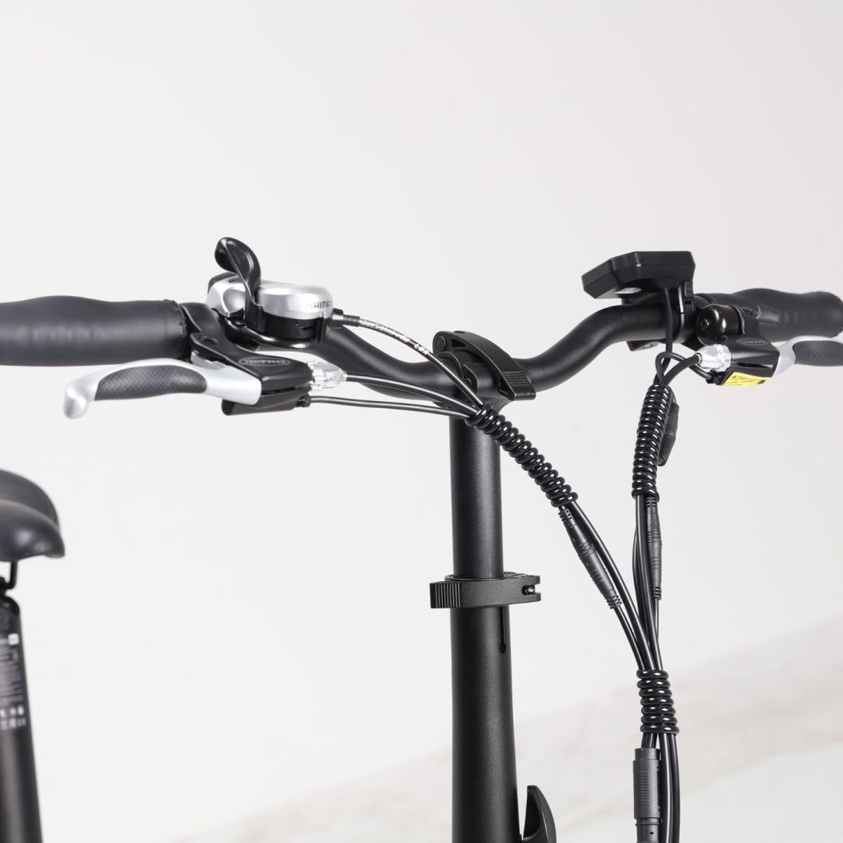 Lenker des E-Bikes. Schwarze Farbe, Bremshebel, Klingel und Bedienelemente. Kabel.