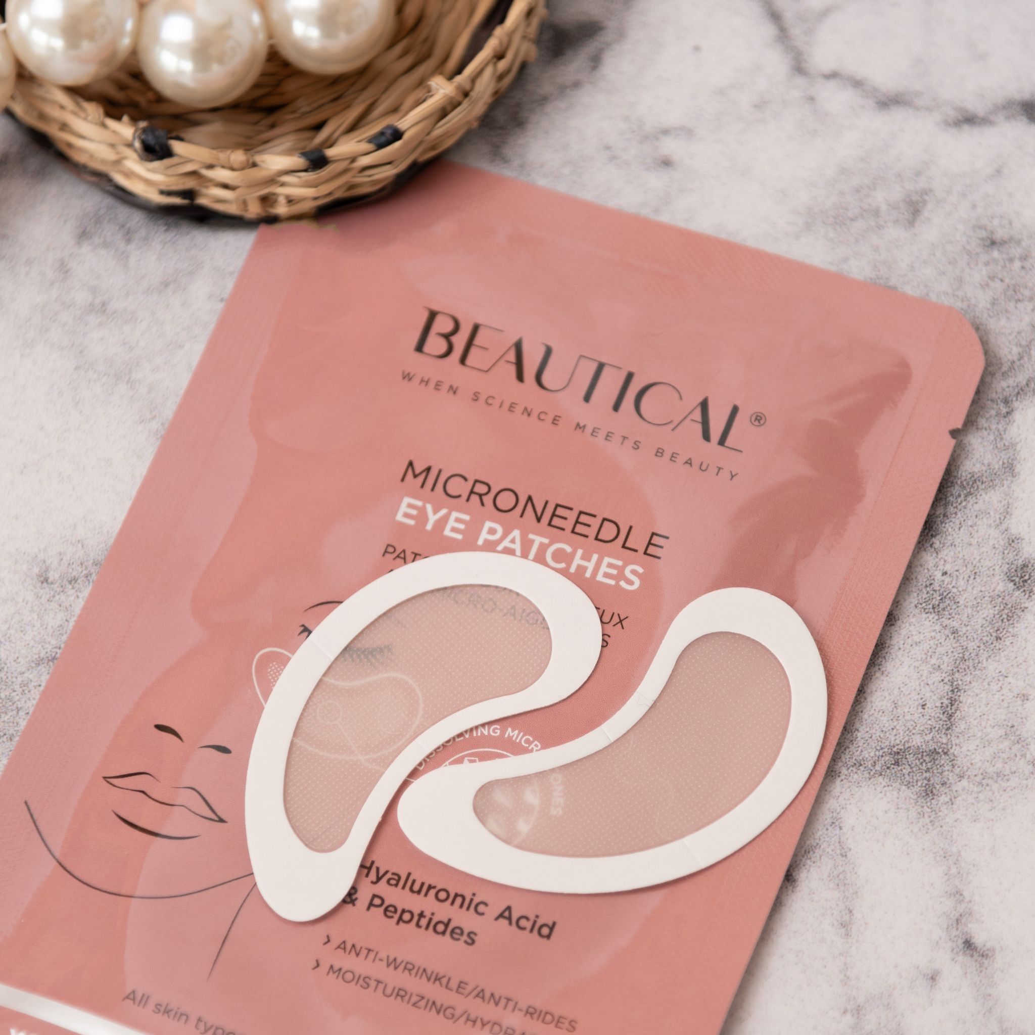 Rosa BEAUTICAL Verpackung mit zwei Augenpads und Perlen. Text: Mikronadel-Augenpads, Hyaluronsäure & Peptide.