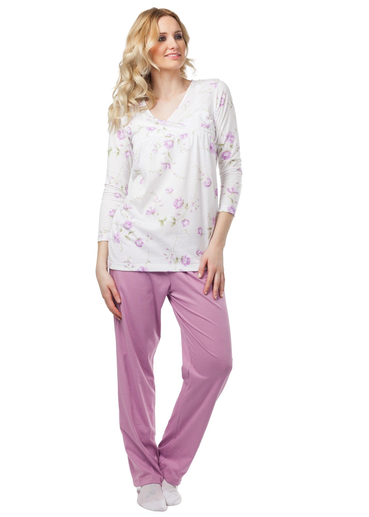 Rosa Pyjama-Set mit Blumenmuster. Oberteil mit V-Ausschnitt und langen Ärmeln. Hose in Rosa. Frau trägt Pyjama.