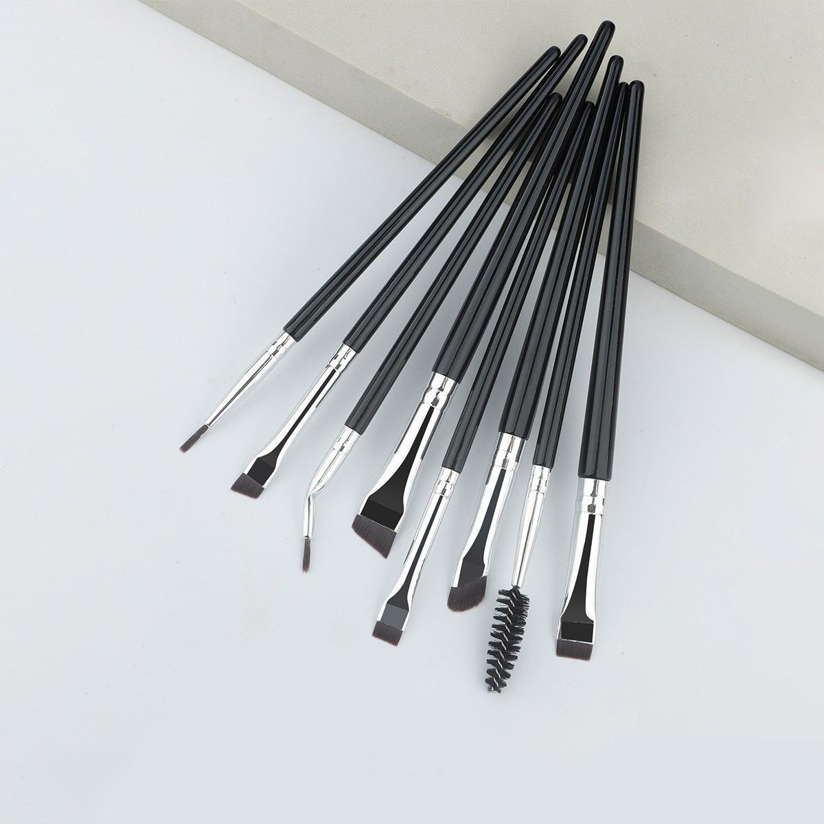 Set mit acht schwarzen Make-up-Pinsel mit silbernen Zwingen und verschiedenen Spitzenformen.