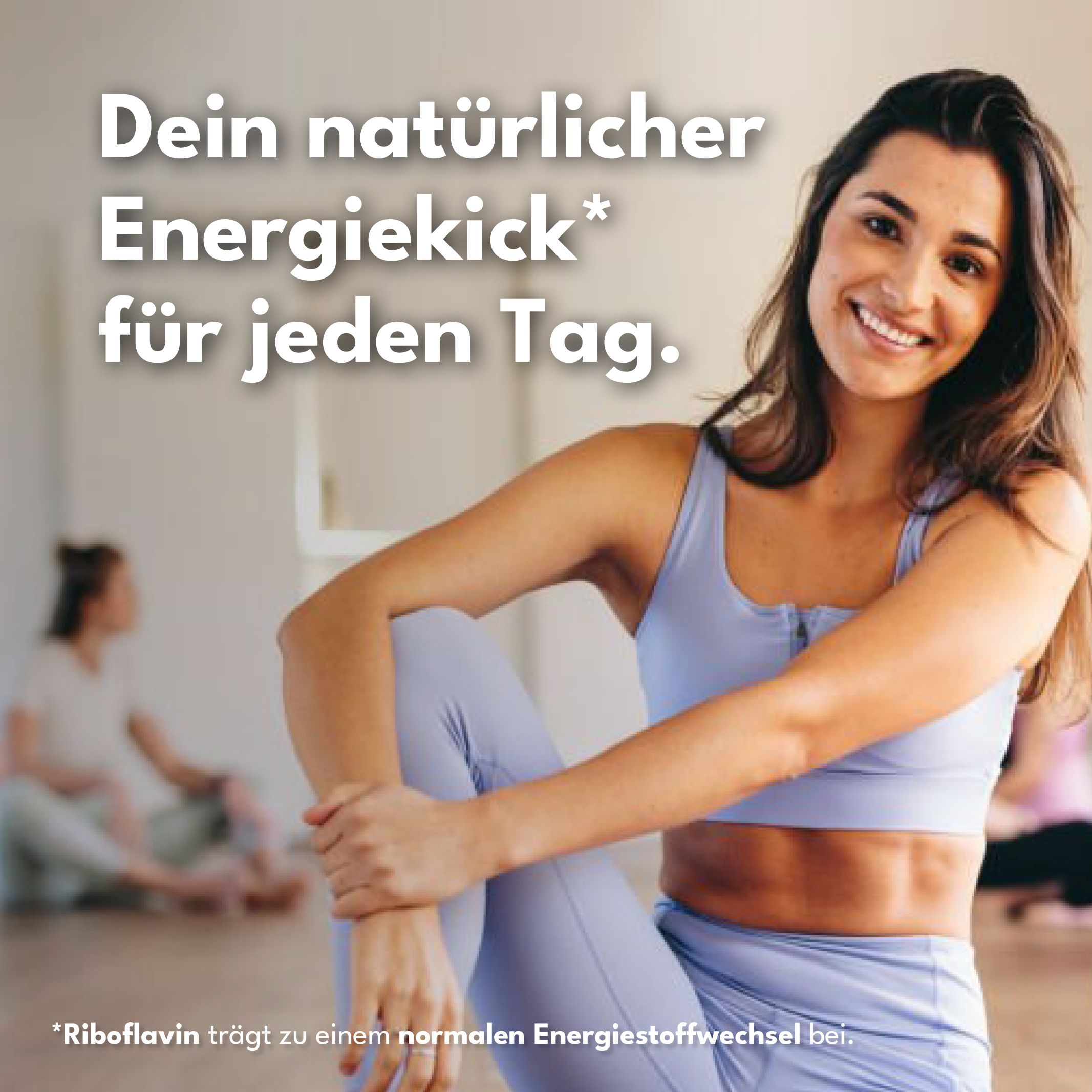 Frau sitzt lächelnd. Text: Dein natürlicher Energiekick für jeden Tag. Riboflavin trägt zu einem normalen Energiestoffwechsel bei.