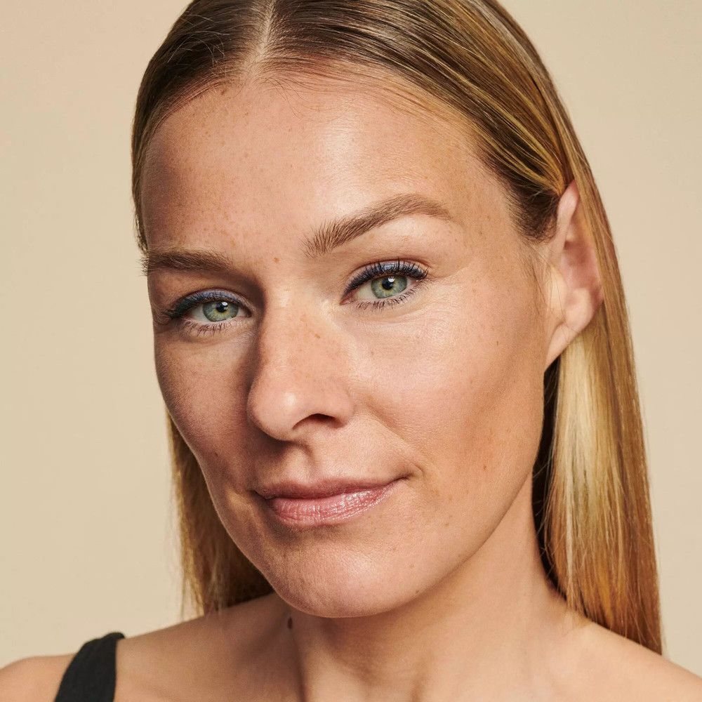 Porträt einer Frau mit blauem Lidstrich. Blonde Haare, helle Haut. Blick nach rechts.
