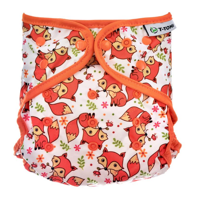 Weiße Stoffwindel mit orangefarbenen Füchsen-Muster. Mit Druckknöpfen und orangefarbenen Rändern. T-TOMI-Logo.