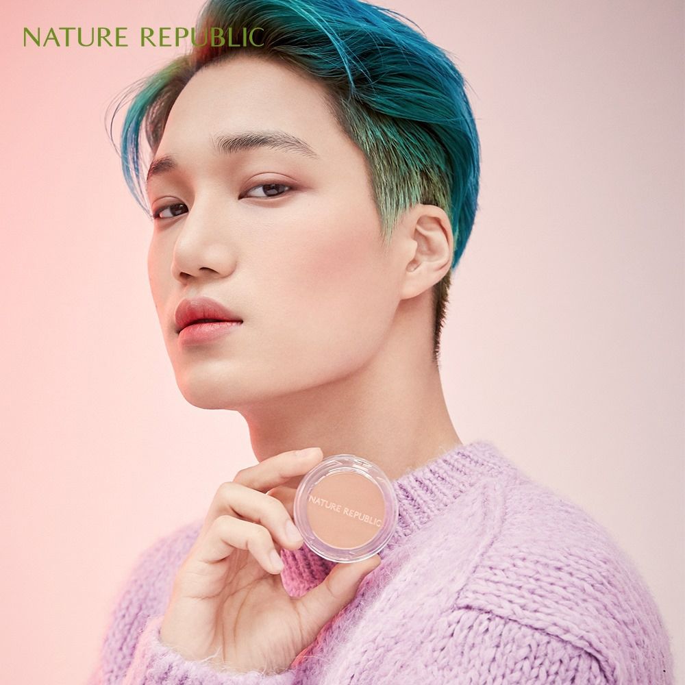 Person hält eine runde, transparente Dose mit rosafarbenem Puder. Auf der Dose steht NATURE REPUBLIC.