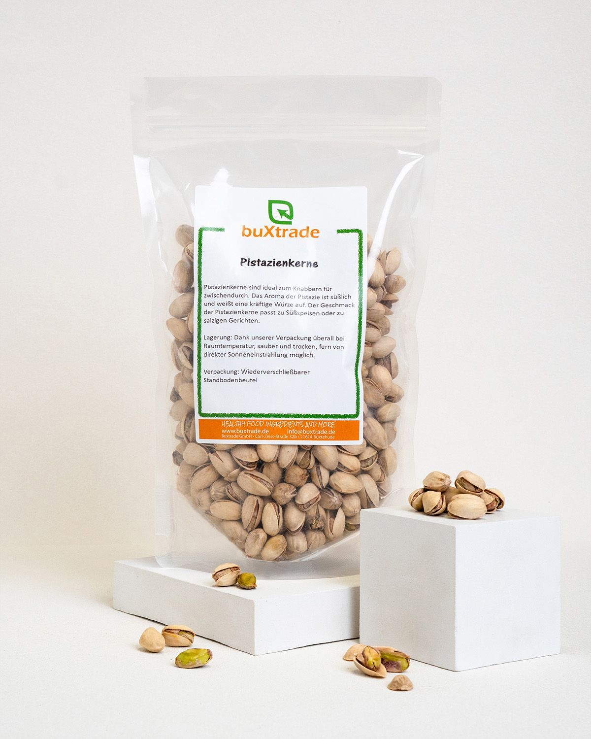 Transparente Verpackung mit Pistazienkernen. Auf weißem Podest. Marke: buXtrade.