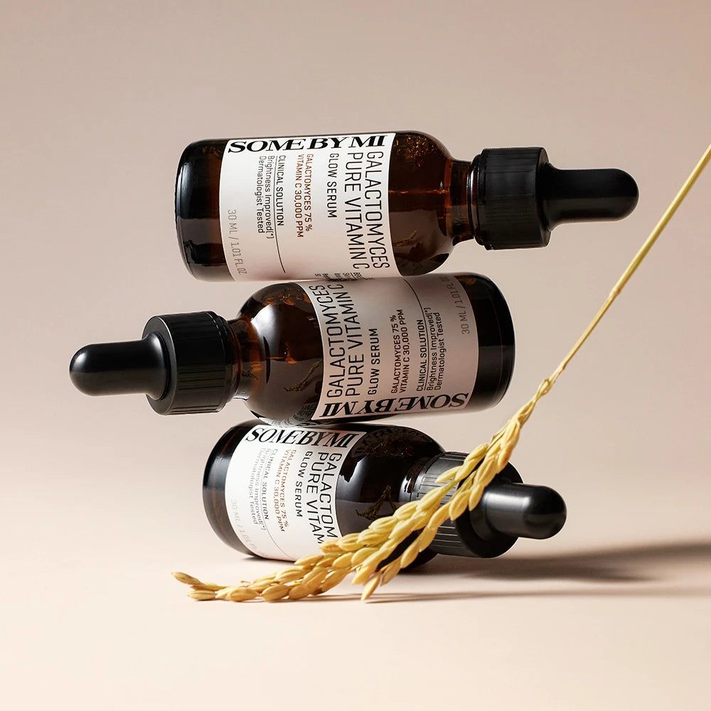 Drei Flaschen Serum, braunes Glas, schwarze Tropfer. Etiketten mit Produktinformationen. Dekoration mit Getreide.