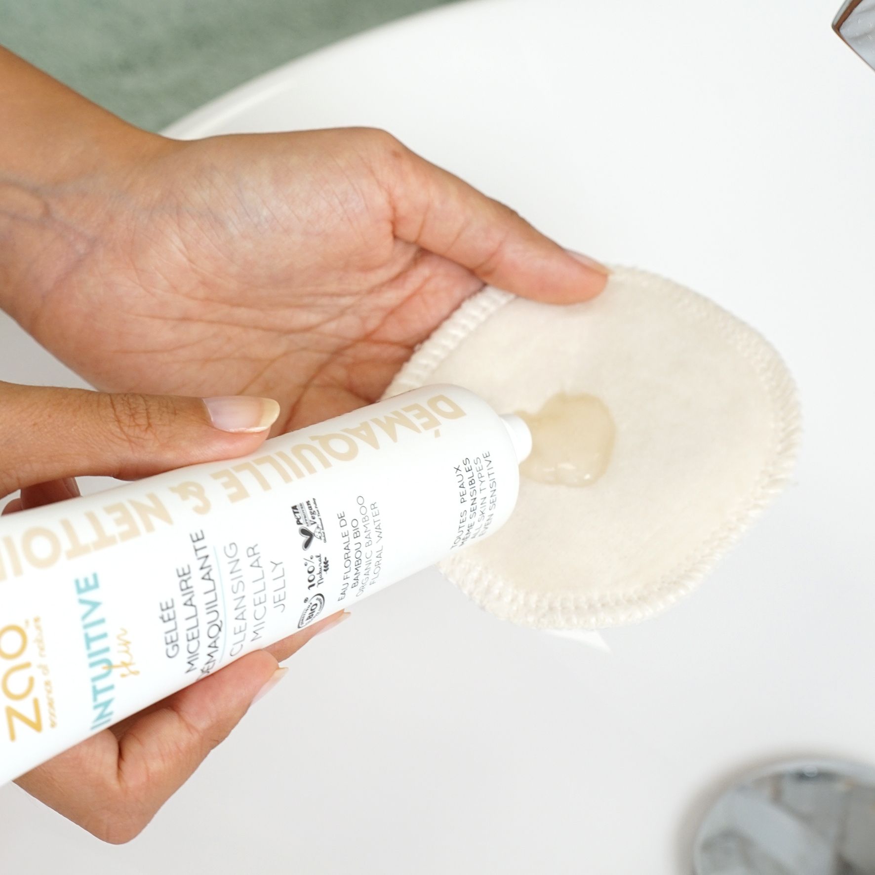 Weiche, runde Wattepad mit Gel. Eine Hand hält das Pad, die andere drückt Gel aus einer Tube.