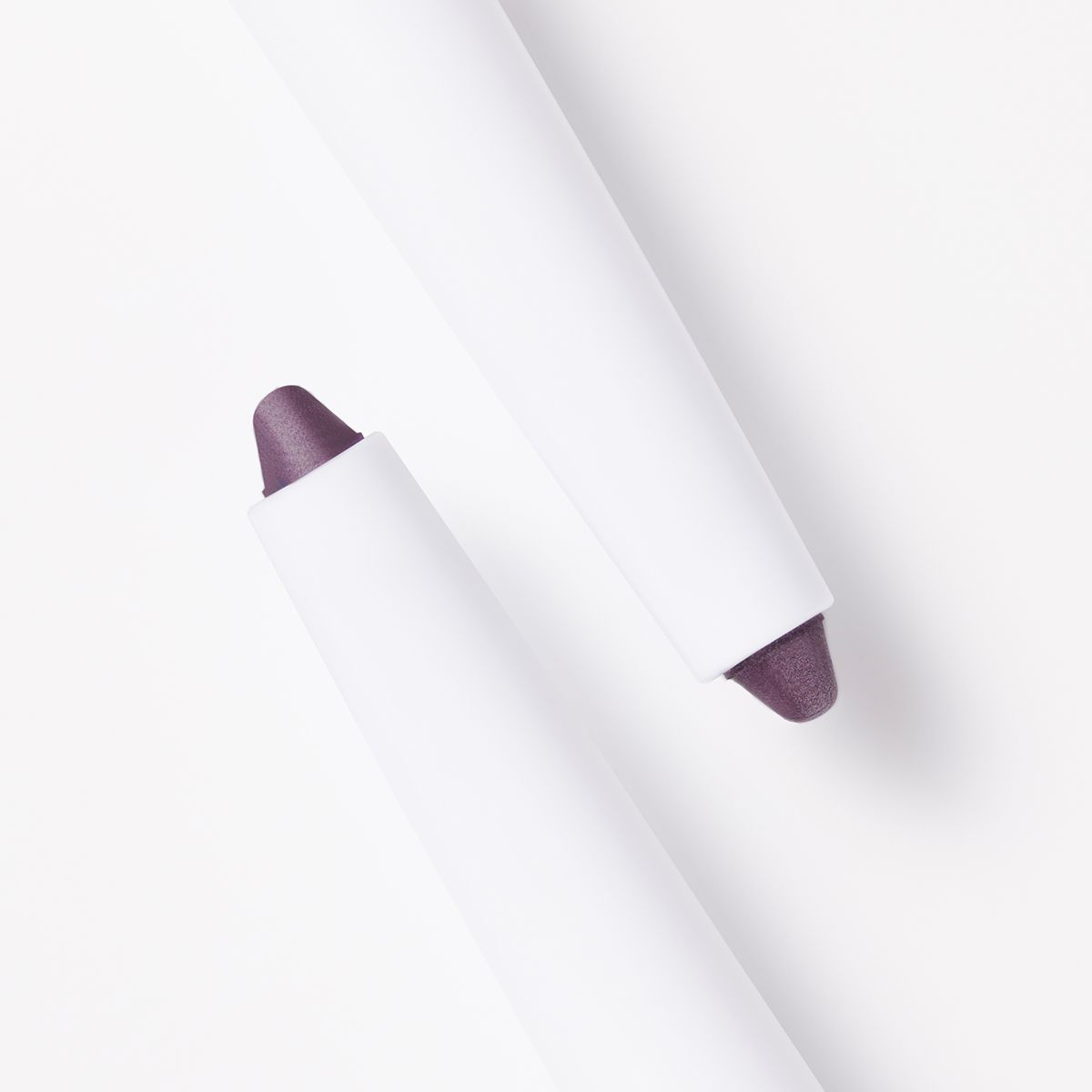 Zwei weiße Kajal-Eyeliner-Stifte mit malvenfarbener Spitze. Die Stifte sind nebeneinander angeordnet.