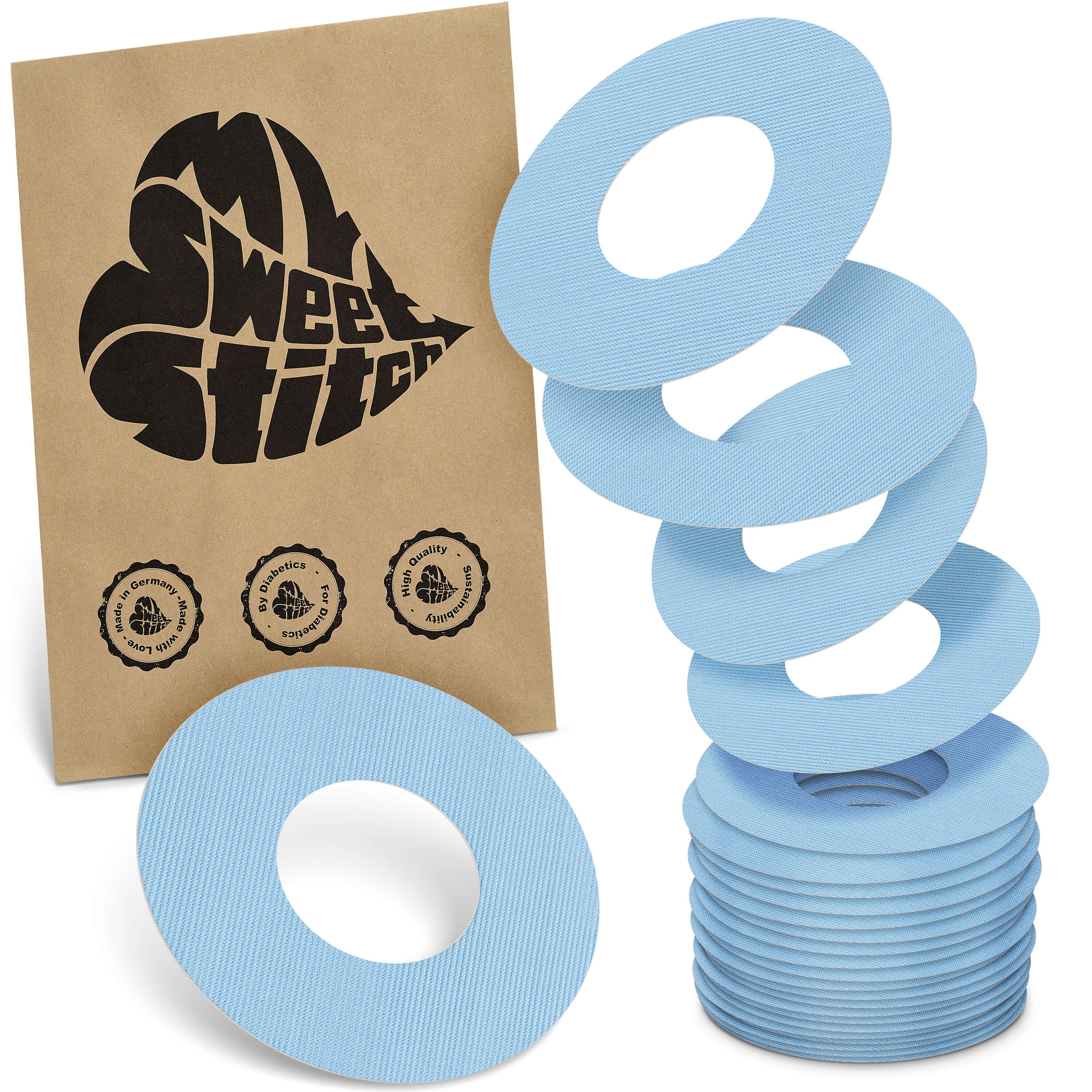 Hellblaue Ringpflaster. Eine Packung mit Logo und Siegeln. Stapel und lose Ringe sichtbar.