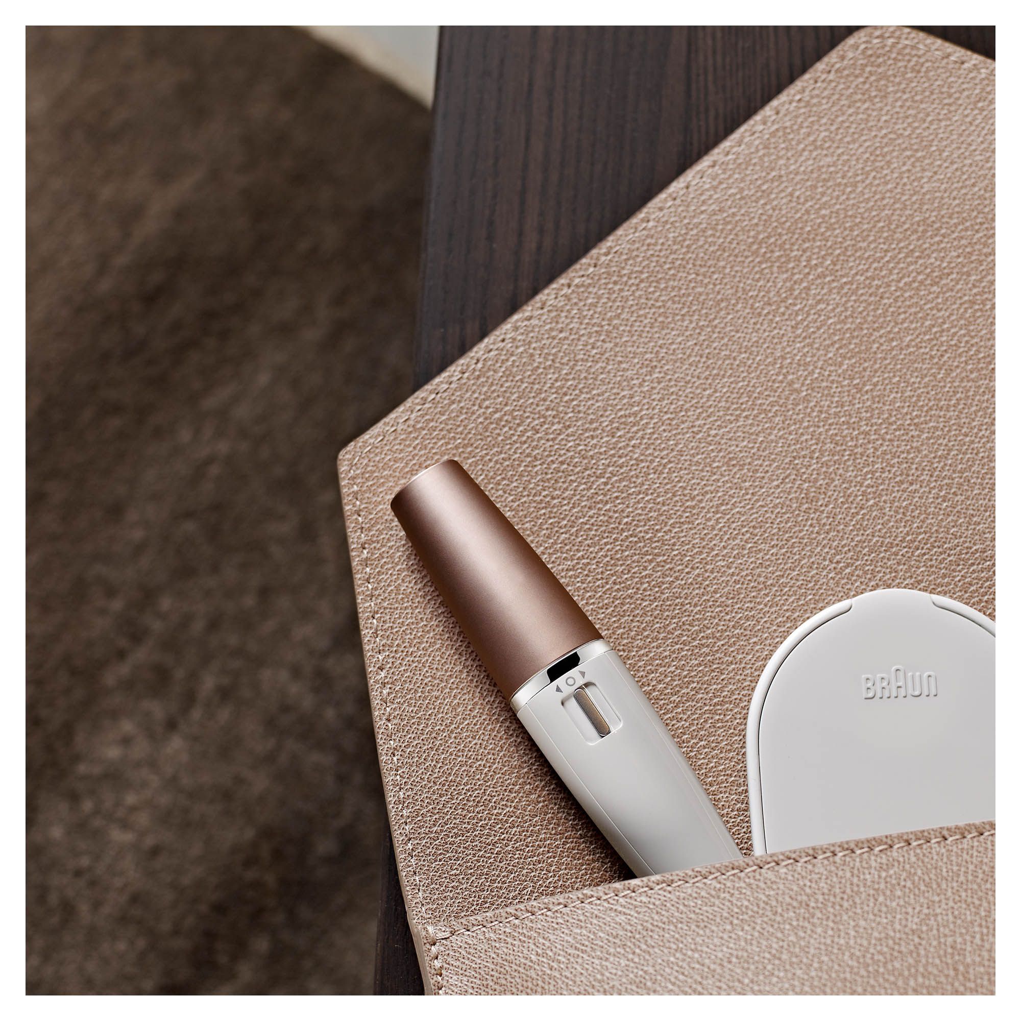 Gesichtsreinigungsbürste und -epilierer, weiß, mit Zubehör in einer hellbraunen Kosmetiktasche.