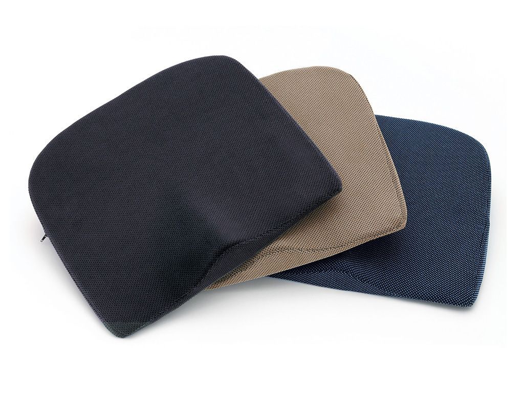 Drei Keilkissen in verschiedenen Farben: dunkelblau, beige und blau.