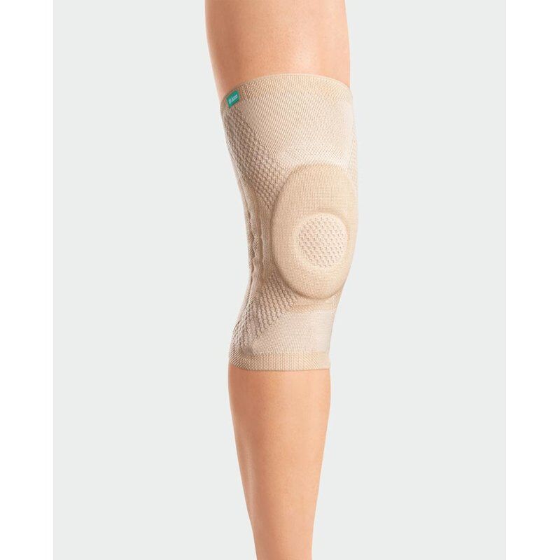 Beige Kniebandage JuzoFlex Genu Xtra am Bein. Mit Noppenhaftrand und Kniepolster. Juzo Logo.
