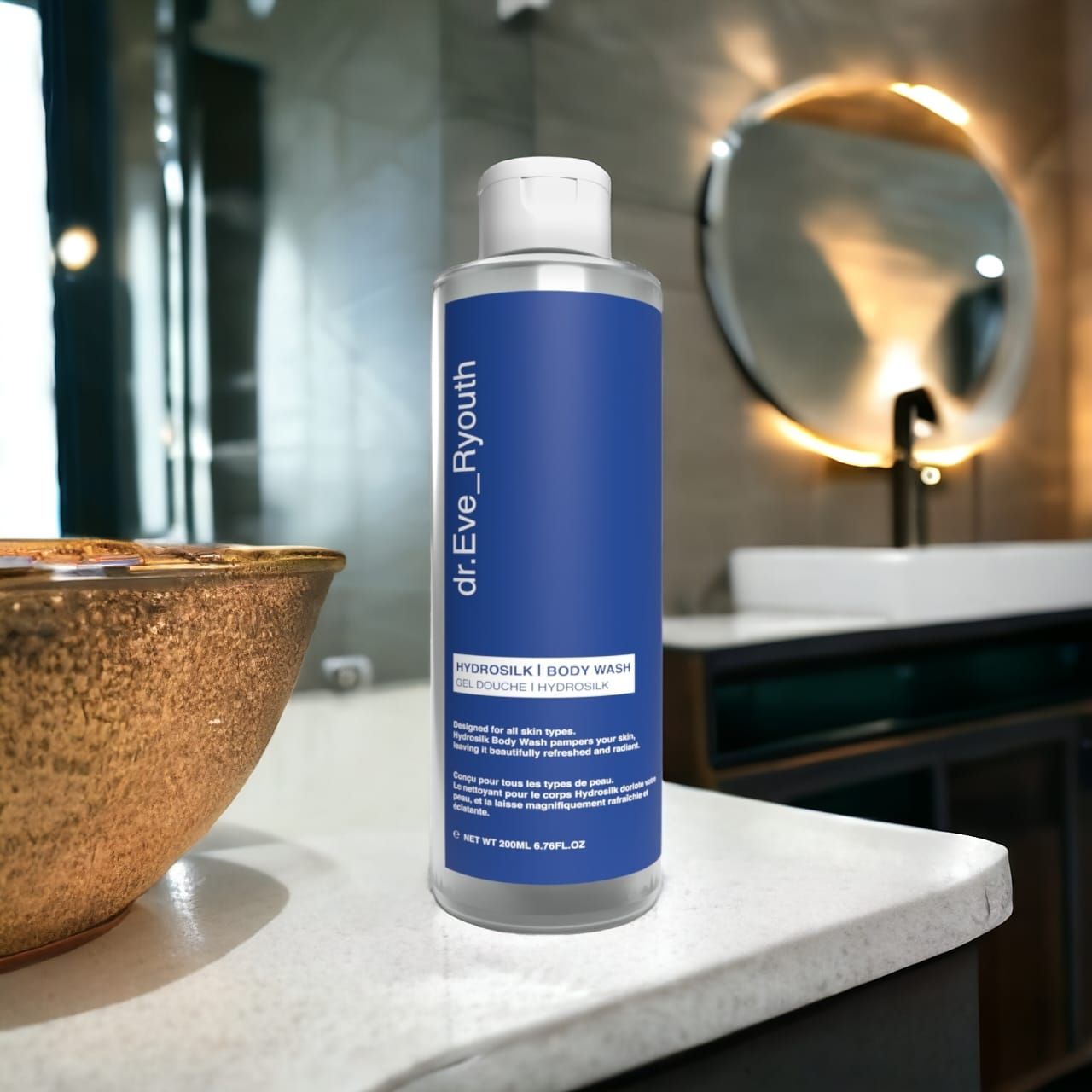 Klarflasche mit blauem Etikett. Aufschrift: dr.Eve_Ryouth, Hydrosilk Body Wash. Badezimmer-Szene mit Spiegel und Waschbecken im Hintergrund.