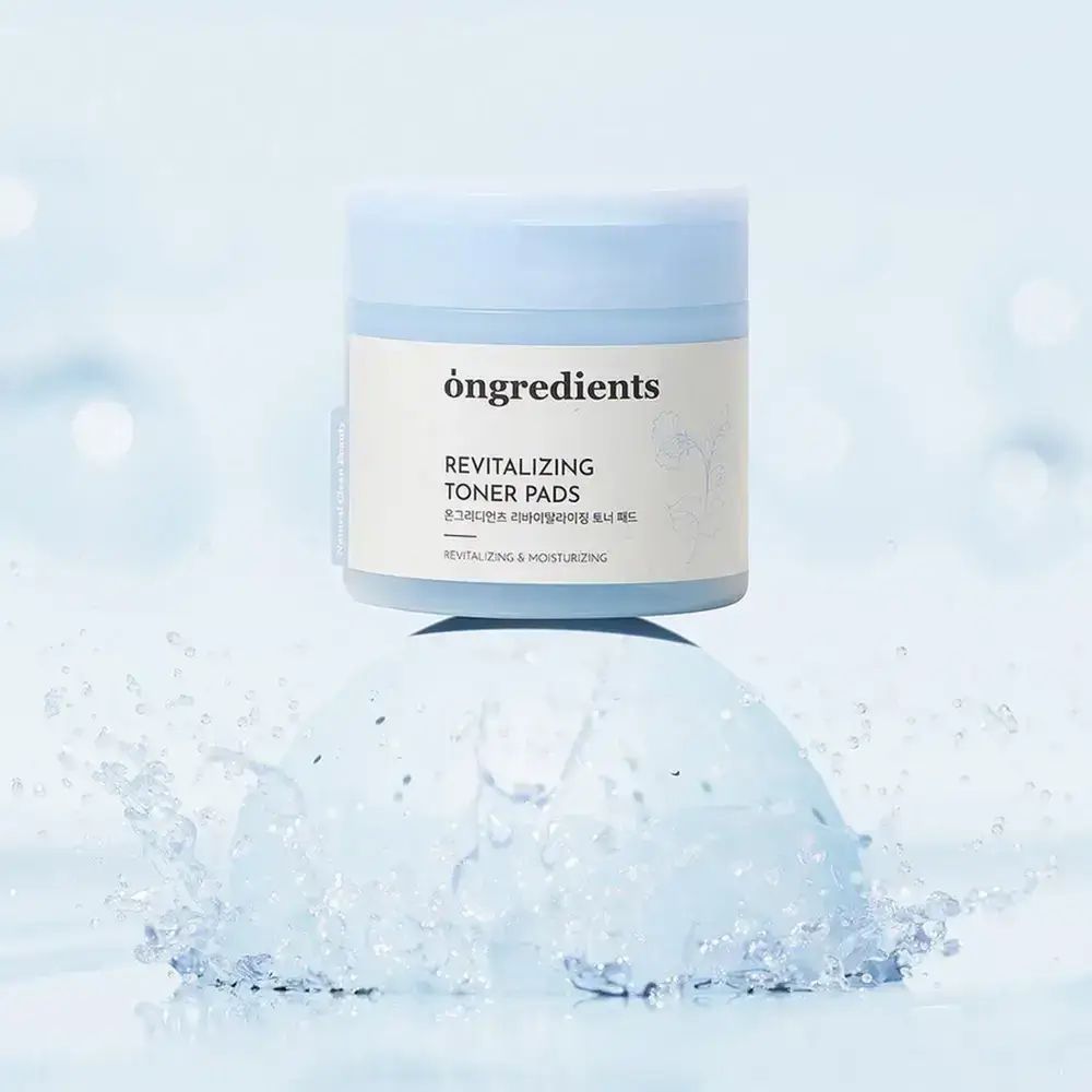 Blau-weiße Dose "ongredients Revitalizing Toner Pads" auf blauem Podest, umgeben von Wasser. Produktpräsentation.