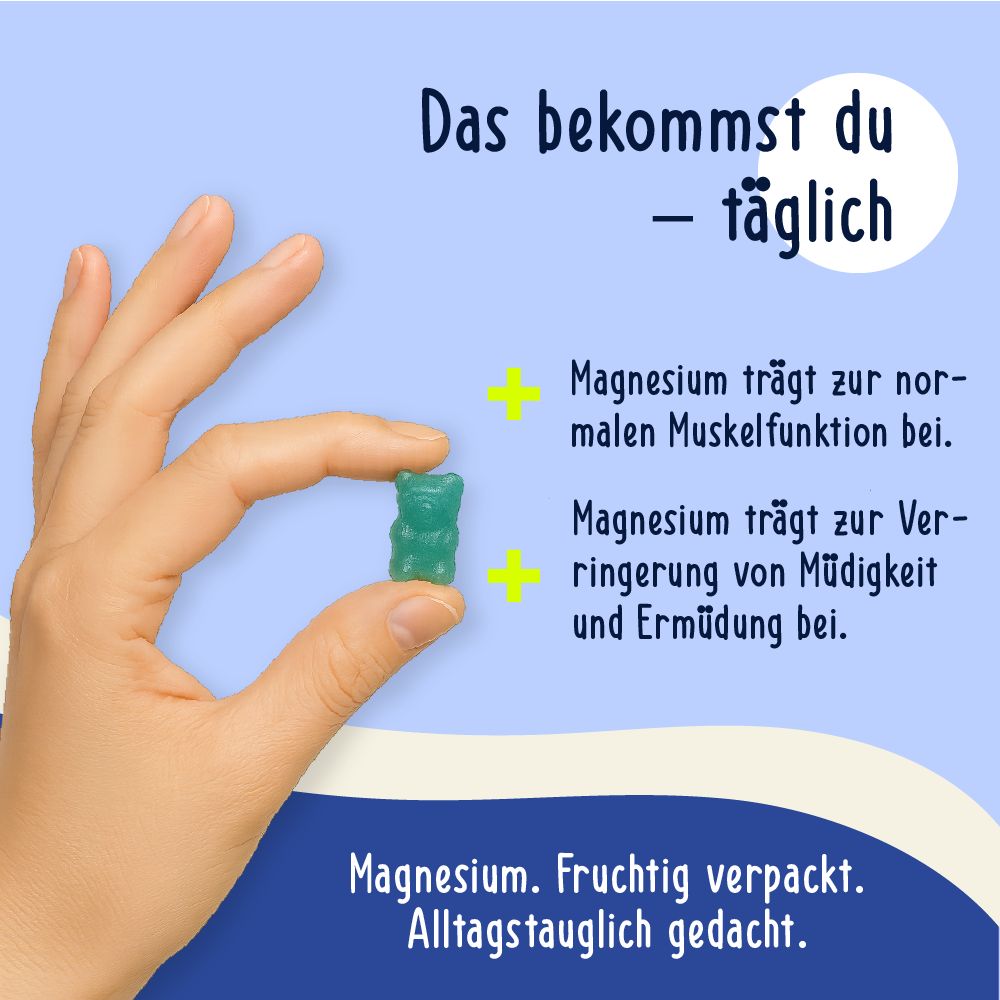 Hand hält ein blaues Gummibärchen. Text: Magnesium trägt zur Muskelfunktion bei, zur Verringerung von Müdigkeit. Fruchtig verpackt.