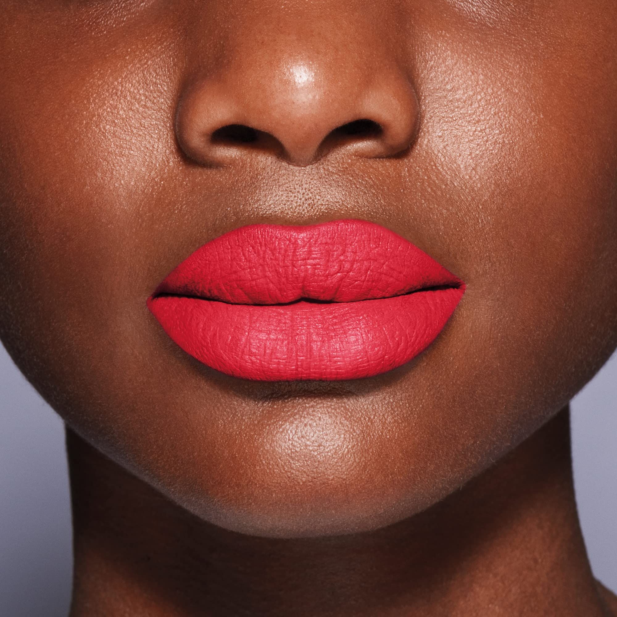 Nahaufnahme von Lippen mit rotem Lippenstift. Hautton dunkel. Lippen sind voll und glänzend.