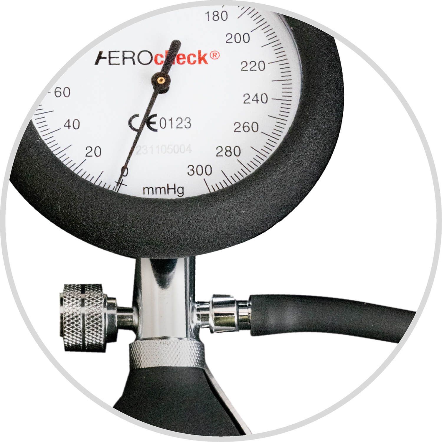 Nahaufnahme des Manometers eines Blutdruckmessgeräts. Schwarzer Rand, weiße Skala mit Zahlen. Aufdruck: AEROcheck, CE-Zeichen, mmHg.